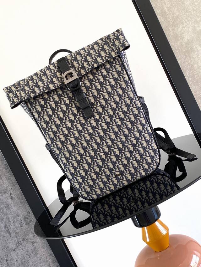 这款 Dior 8 卷顶双肩背包是二零二五春季男装系列新品，时尚且实用。采用黑色 Oblique 印花面料等材质精心制作，搭配带有 Dior 8 搭扣的自扣式翻