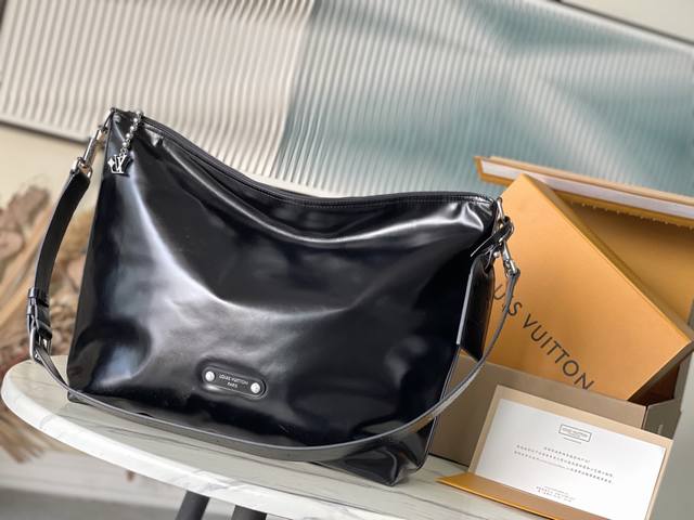 头层皮 顶级原单M13986 本款Vagabond Hobo手袋以亮面软牛皮革构筑符合人体工学的贴身廓形，无论斜挎或肩背，皆能展露飒爽风姿。金属拉链实现顺畅开合