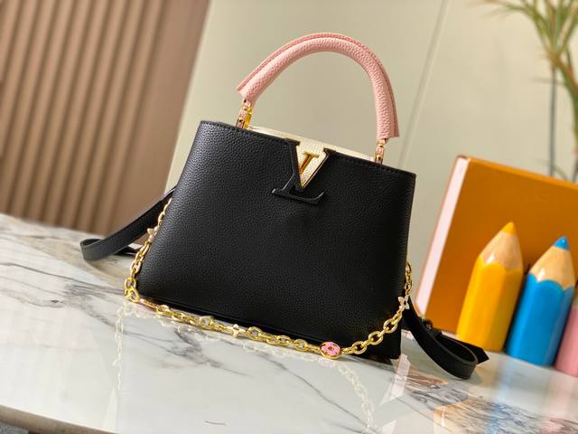 升级版 M20844黑粉花卉三拼 本款 Capucines Bb 手袋取材 Taurillon 皮革，隐约映现同一色彩的浓淡变化，令经典构型更为瞩目，搭配珐琅