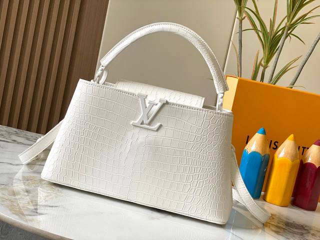 升级版 M23978白色鳄鱼纹本款Capucines大号手袋为哑光Taurillon牛皮革搭配金属件,令经典设计展露利落风范。翻盖提供外置或内收两式风尚,齐整内 升级版 M23978白色鳄鱼纹本款Capucines大号手袋为哑光Taurillon牛皮革搭配金属件,令经典设计展露利落风范。翻盖提供外置或内收两式风尚,齐整内
