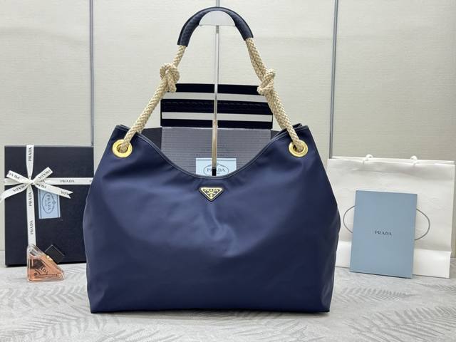 新款托特包1Bc244大购物袋蓝色 这款再生尼龙包袋灵感源自海洋风格的经典元素 采用新颖精美搭配 彰显活泼个性风格 滑动编绳手提柄为这款多功能配饰勾勒Overs