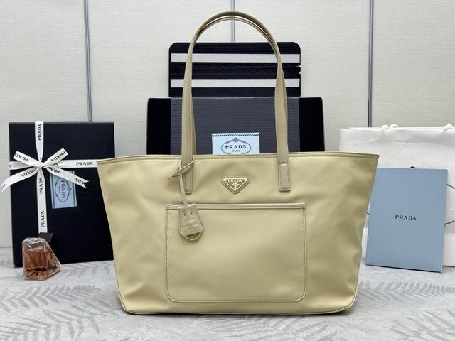 新款托特包中号1Bg555杏色这款经久不衰的托特包是对经典设计的重新演绎 采四进口尼龙面料 以精致而实用的廓形展现了独特风格 线条简洁大气 容易空间大 实用又时