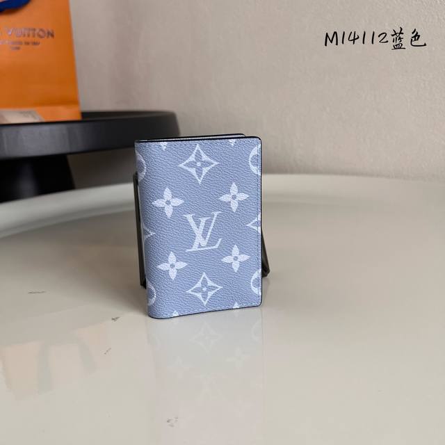 出厂价p M14112蓝色 這款小巧玲瓏的袋裝萬用錢包採用同色調的Monogram帆布及Taga皮革製造 以絢麗奪目的色調讓人回想起晚春的華彩 錢包的尺寸可放入