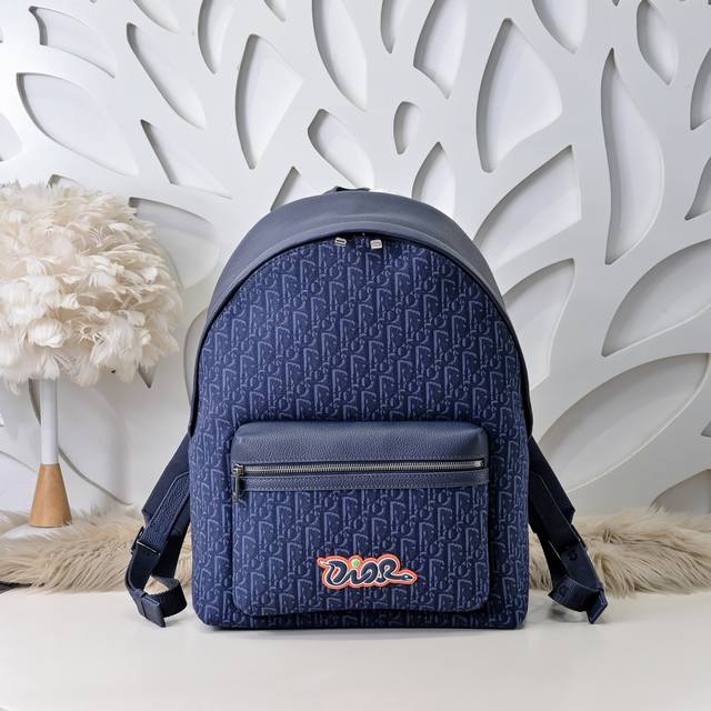 dior-迪奥专柜最新款双肩背包官网同步 本季新品 采用海军蓝色粒面牛皮革等材质精心制作 正面大号拉链口袋饰以同色调Oblique印花 搭配海军蓝色和朱红色Di