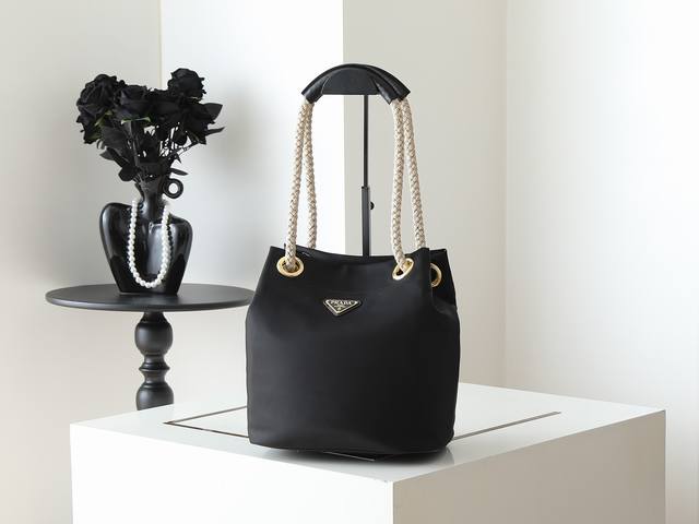 原单 新款水桶包1Be082走秀款 这款再生尼龙包袋灵感源自海洋风格的经典元素 采用别致精美搭配 彰显活泼个性风格 滑动绳带手提柄搭配涂珐琅三角形金属徽标 突显