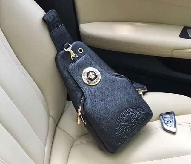 范思哲 此款柔软的牛皮胸包饰有一处压花大圈美杜莎 图案和一枚同色美杜莎版饰 配有顶部大五金Logo 顶部有耳机穿孔 可调节肩带.材质 织物 牛皮 意大利制造 规