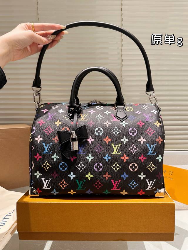 30手袋] M13257 黑彩 本款30手袋取材柔软涂层帆布 以缤纷彩虹色调描摹全幅图案 牛皮革构筑手柄和可拆卸肩带 金属包角回溯经典行李箱元素 蝴蝶结造型钥匙