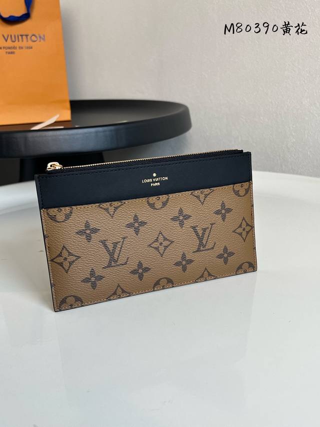 芯片版 M80390黄花 Slim Purse 手拿包采用 Monogram 帆布和丝滑牛皮实现简约构型，点缀路易威登标识压纹，设有拉链主隔层、外贴袋、外隔层和