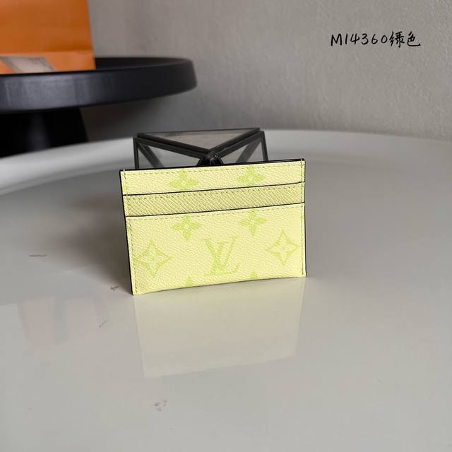 M14360绿色 此款采用全新Monogram Eclipse涂层帆布材质的卡片夹风格靓丽而时髦，体积小巧，可轻松收入口袋中。配有中央口袋与四个插槽，可存放信用