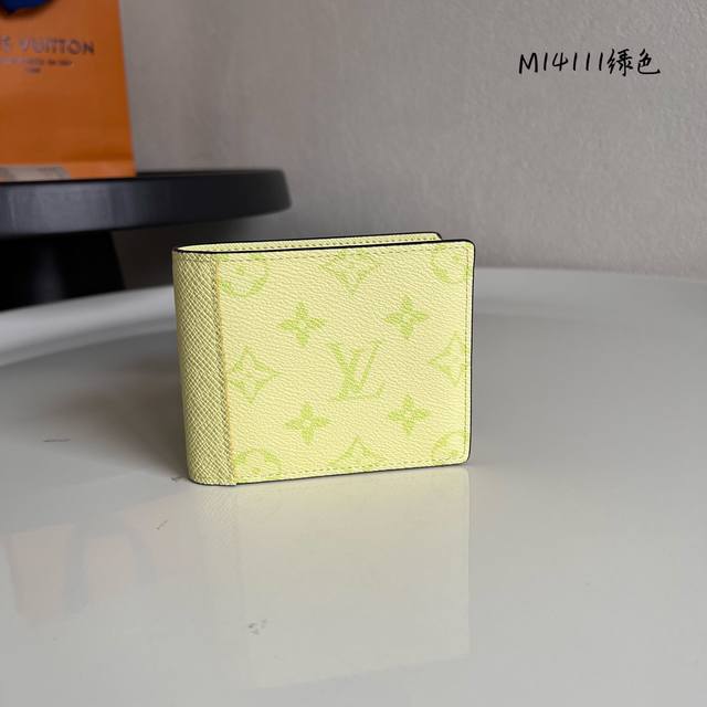 M14111绿色 這款尺寸小巧的Multiple錢包以同色調的Monogram帆布搭配Taga皮革，展現俐落清爽的配色，散發活潑的運動氣息。內層配上黑色牛皮襯裡