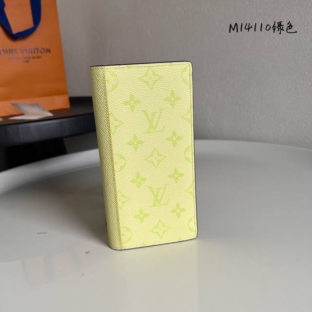 M14110 绿色 Brazza長型錢包以色彩絢麗的Monogram塗層帆布搭配色調相襯的Taga皮革製造。精心設計的內層設有十六個信用卡夾層、拉鏈零錢格及多個