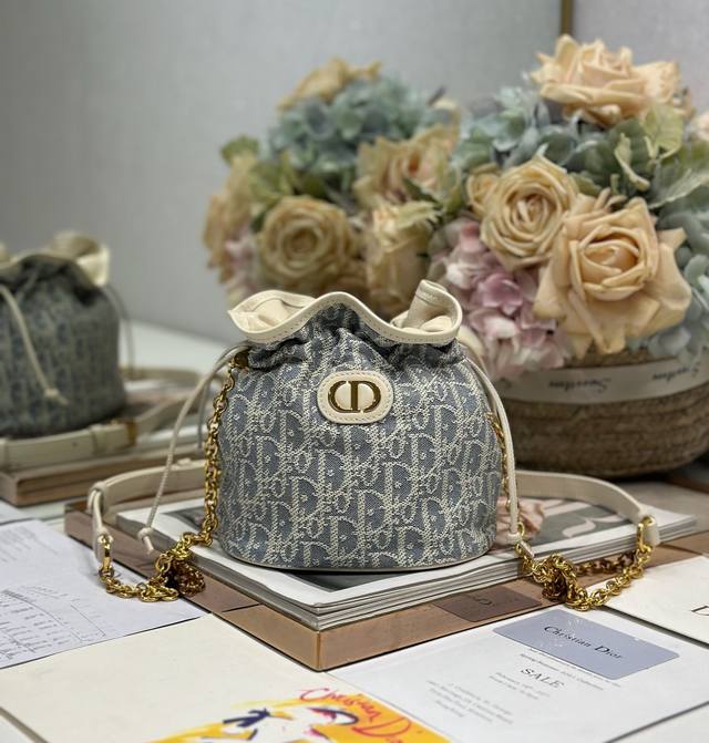 30 Montaigne 迷你抽绳水桶包 灰D布 这款迷你抽绳水桶包是二零二五早春成衣系列新品，以休闲优雅的设计丰富 30 Montaigne 系列。采用米白牛