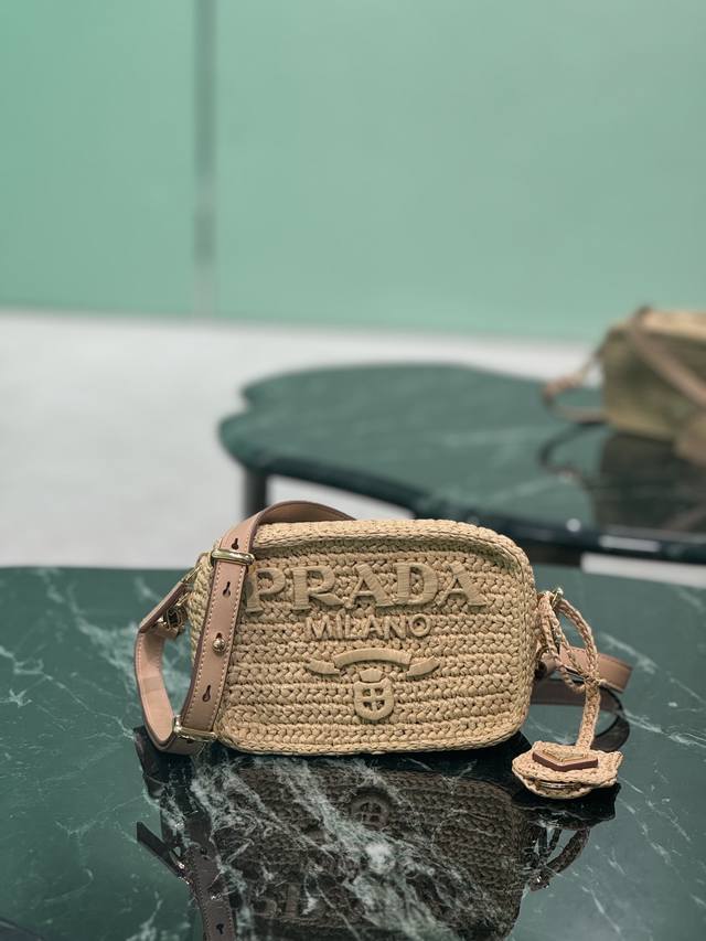 草编相机包 夏天里的一道光，整个包身采用顶级拉菲草纯手工制作，Logo纯手工包制，配有一条可调节长肩带，背面设计三角标五金！ 款号：1Bh196 尺寸：长20X