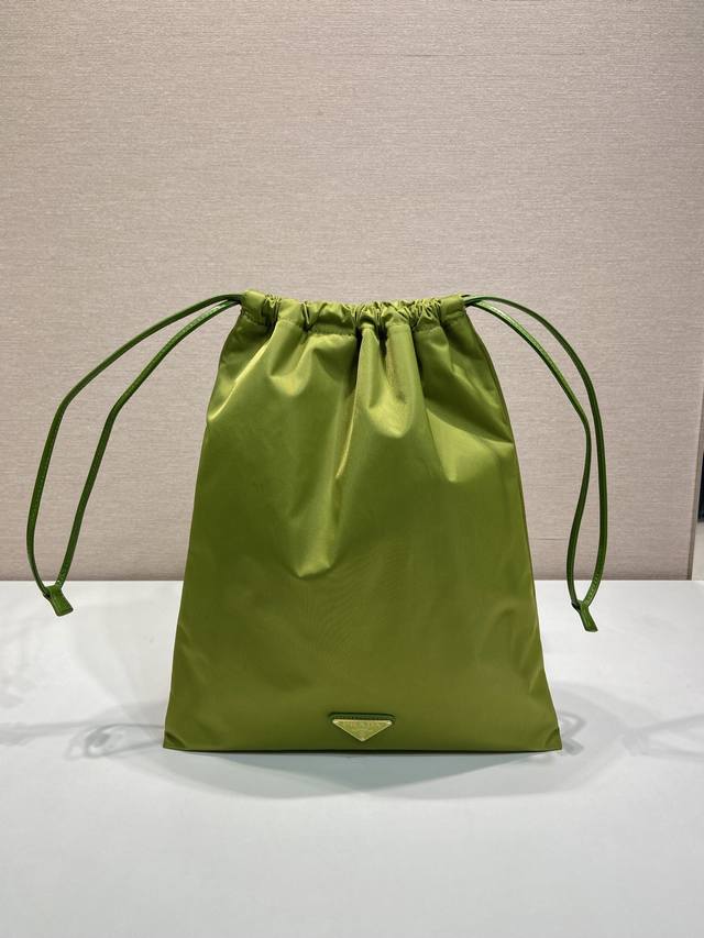 配专柜包装新品手包1Nk001抽绳小袋 这款抽绳小袋由Re-Nylon尼龙面龙制成，小牛皮革抽绳包口，涂珐琅三角形金属徽标，Re-Nylon衬里配有贴袋，又可当