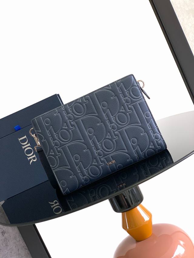 市场最高对版版本 这款 A5 三角形手拿包是 Dior 的主打单品。采用海军蓝色 Dior Gravity Outline 皮革精心制作，这是一种压花粒面牛皮革