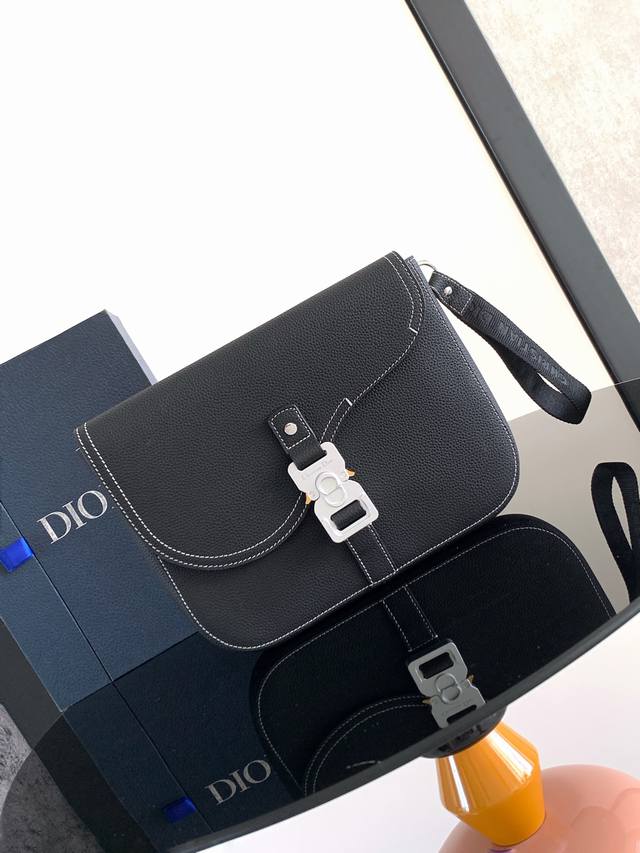 这款 A5 马鞍手拿包以时尚优雅的设计提升经典马鞍系列的格调。采用黑色粒面牛皮革精心制作，饰以对比鲜明的缉面线，马鞍翻盖点缀以 Christian Dior 标