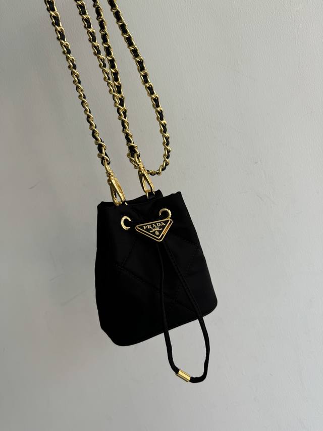 绣格小水桶1Nr016手工绣格 这款绣格小水桶采用复杂绣格手工和进口尼龙面料，涂珐琅金属三角形徽标装饰开合设计。金属铁琏可斜跨。太可爱了，上身的效果非常吸眼，可