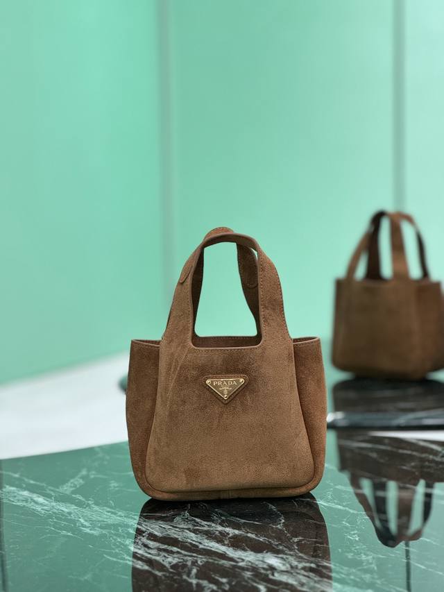 菜篮子水桶包 秋冬季麂皮手袋，里外全皮配有双提手饰以金属徽标，整体包身非常柔软轻巧，格调优雅出类拔萃，两个侧面口袋既满足精致收纳需求，又平添高雅韵味，可手提可当