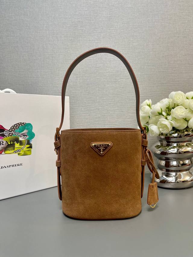 厂价 。 最高版本原厂皮顶级原单配专柜全套包装 顶级原单 新款水桶包1Be078鹿绒皮小号這款靈活易搭的水桶袋設計極簡，以柔軟的麂皮製作。肩带可调节，内配进口羊