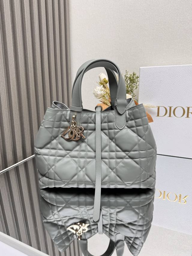 Dior Toujours 手袋〔岩石灰色中号〕 这款Dior Toujours 手袋于二零二三春夏系列发布秀精彩亮相,休闲实用的设计别具一格.采用白色牛皮革精
