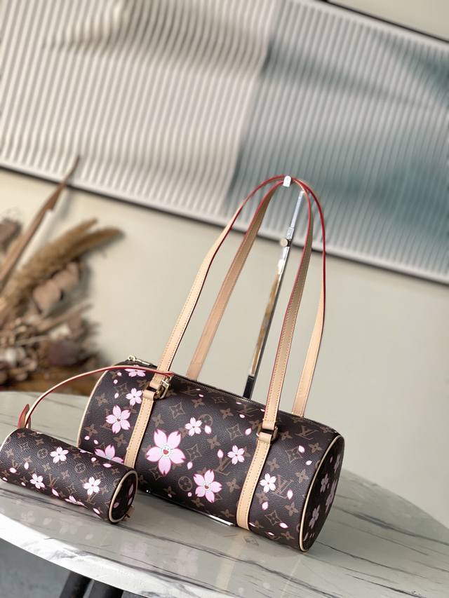 顶级原单 M13097 本款Papillon手袋以Monogram涂层帆布和皮革饰边造向圆柱构型，并通过金属件巧妙衔接其袖珍版本。路易威登×村上隆复刻系列的Ch