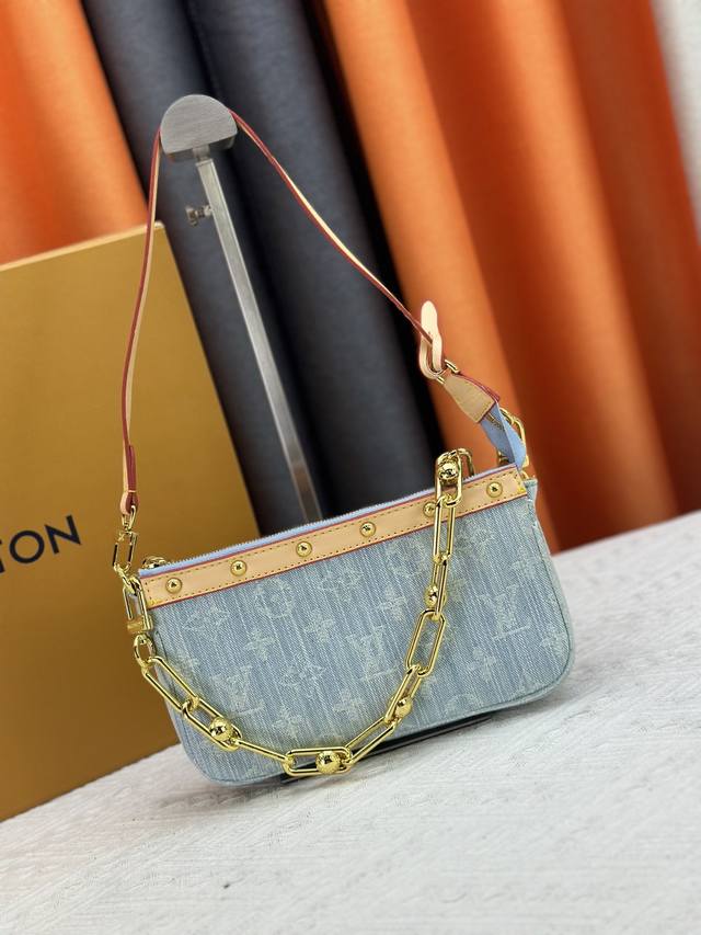 M13404 丹宁牛仔本款 Pochette Accessoires 手袋取材涂层帆布，以缤纷 Monogram 图案演绎路易威登×村上隆跨界合作系列的灵动格调