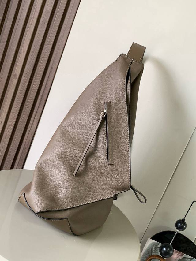 原厂皮 经典款Anton 背包大号这是一款采用柔软粒面小牛皮制成的功能性流线型吊兜带有一条可调节的皮革带和拉链顶部设计使用时可以折叠并且可以用按扣固定*肩挎或斜