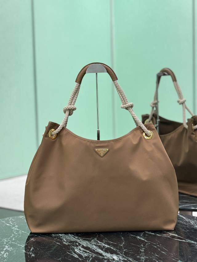 正品级 尼龙托特包 这款再生尼龙包袋灵感源自海洋风格的经典元素，采用新颖精美搭配，彰显活泼个性风格。滑动编绳手提柄为这款多功能配饰勾勒Oversize廓形，涂珐