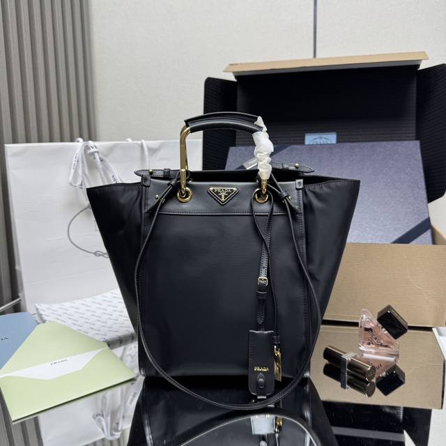 正品级 顶级原单 新款托特包1Bg578这款托特包采用时尚几何造型，融合实用的Re-Nylon再生尼龙材质与精致细节。造型百变，搭配金属与皮革双手提柄，可在手提