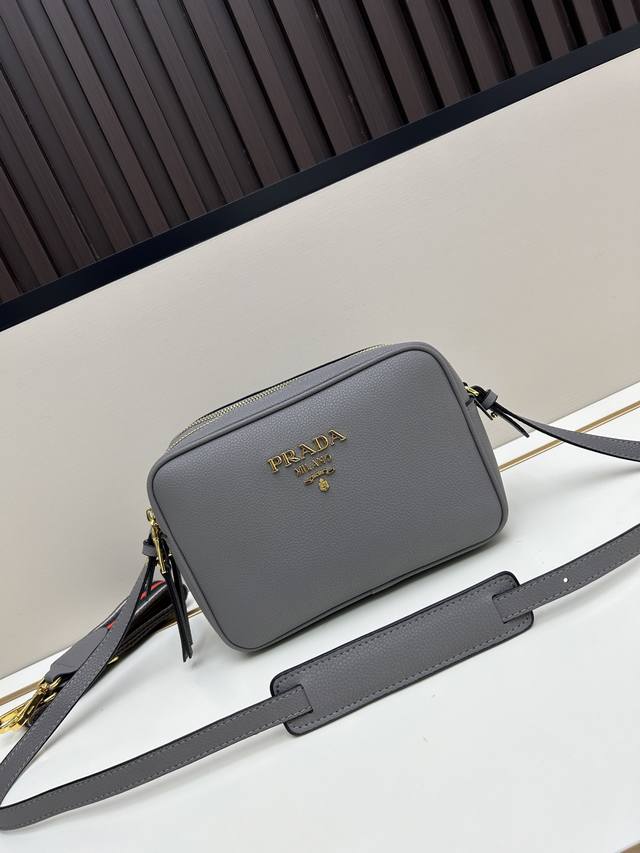 Prada这款双肩带相机包，采用进口头层粗荔枝纹牛皮，配有两条可交换可调节长肩带设计。织物织带和牛皮搭配，太完美，不同场合不同衣着的全能混合搭配，容量空间大，格
