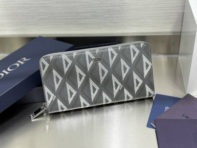 这款长款拉链式钱包低调而不失优雅气质。原单材料精心制作，内部为黑色光滑牛皮革材质。中间的拉链口袋可放置硬币，双层现金隔层和 12 个卡槽提供充足的收纳空间。优雅