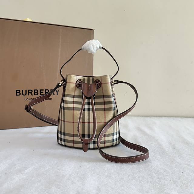 原单B包迷你格纹水桶包，选用涂层棉质混纺面料打造。于意大利工坊精制而成，装饰 Burberry 格纹印花。包型柔软立挺，内衬为棉质面料。搭配抽绳开合，融入皮革盾