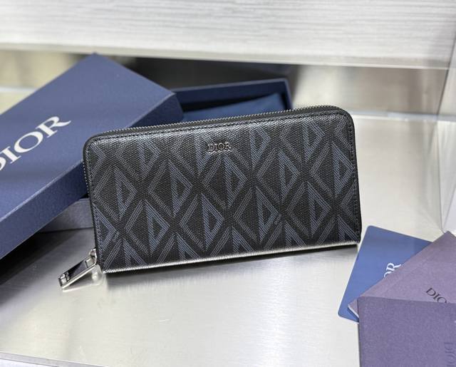 这款长款拉链式钱包低调而不失优雅气质。原单材料精心制作，内部为黑色光滑牛皮革材质。中间的拉链口袋可放置硬币，双层现金隔层和 12 个卡槽提供充足的收纳空间。优雅