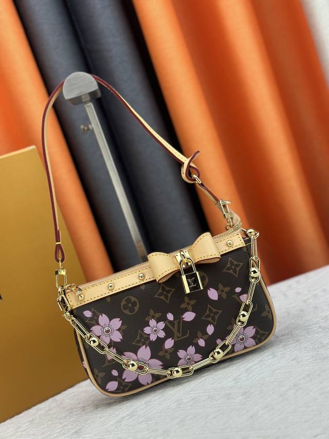 M13666 本款Pochette Accessoires手袋为经典Monogram帆布融入村上隆笔下的明媚Cherry Blossom图案，以玩趣格调出路易威