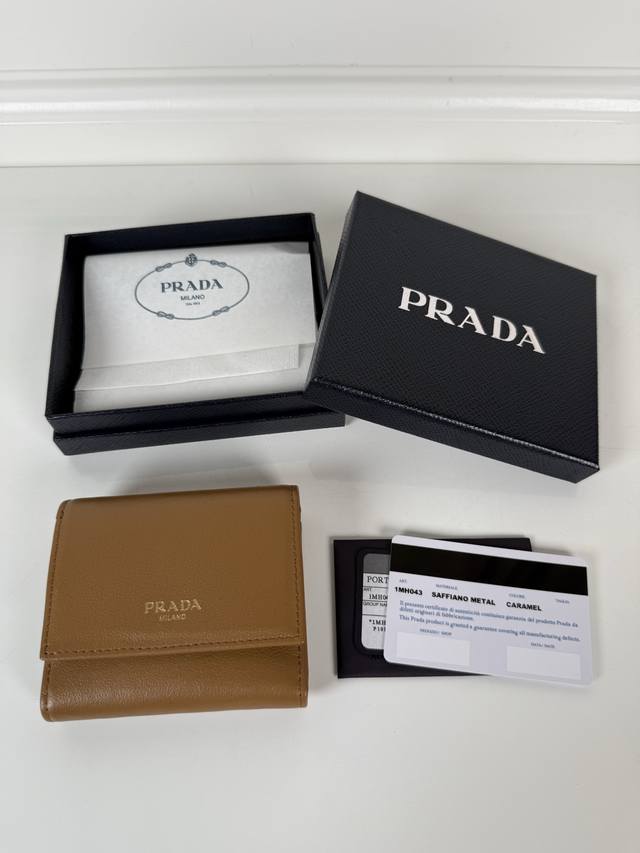 P家女士焦糖细摔皮平纹短夹，原单品质，型号1Mh043，四个卡位插口，一个票据隔层，两个证件袋，一个外部口袋，内部翻盖式零钱袋一个，尺寸10X8.5Cm。。