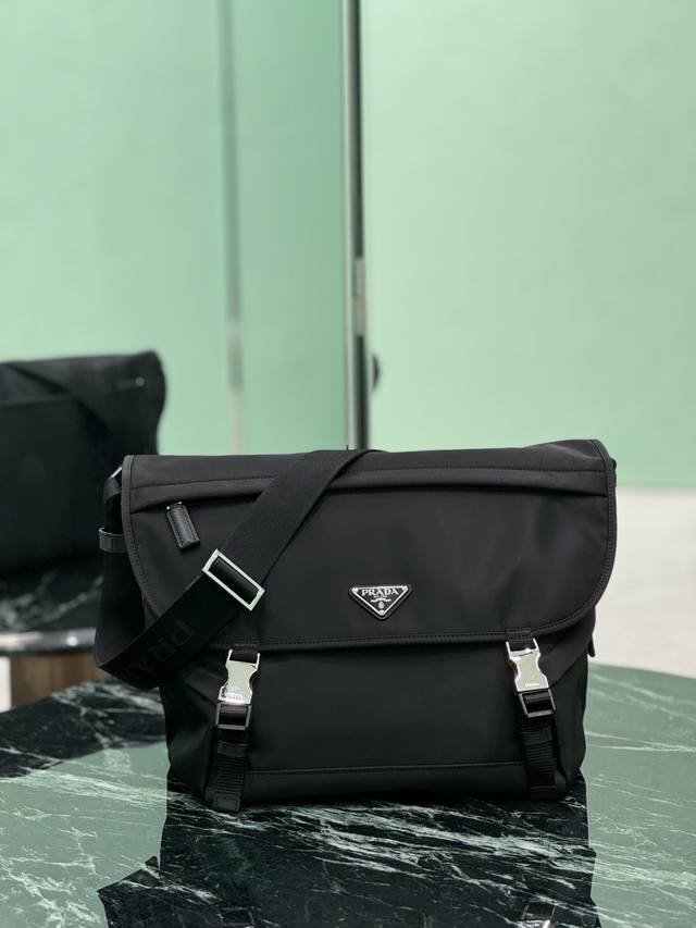 新款邮差包 这款邮差包由Re-Nylon再生尼龙面料设计，翻盖和按锁开合，三个外部拉链式口袋，内部拉链式口袋和贴袋。容量空间大，又是一款永久不过时爆款。帅哥们，