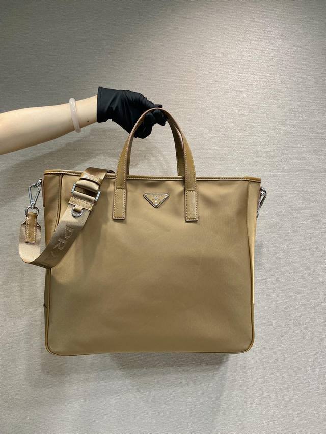 独家首发2Vg064新色 最新款购物袋这款尼龙托特包呈现极简主义设计风格，流露摩登气息。采用进口尼龙布料和Saffiano十字纹牛皮组合成，手袋配有一条可拆卸肩