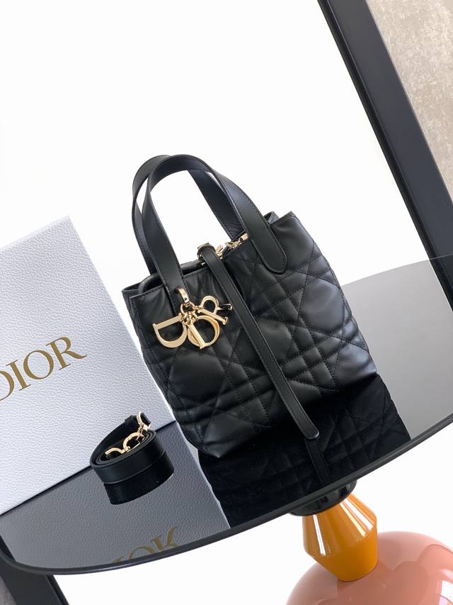 这款 Dior Toujours 竖版手袋时尚实用,别具一格。采用黑色牛皮革精心制作,饰以超大藤格纹缉面线,宽敞的内部隔层可收纳各种日常用品。设有纤细皮革系带开 这款 Dior Toujours 竖版手袋时尚实用,别具一格。采用黑色牛皮革精心制作,饰以超大藤格纹缉面线,宽敞的内部隔层可收纳各种日常用品。设有纤细皮革系带开