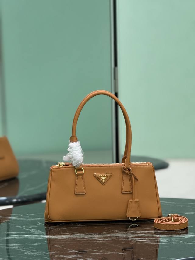 长柄杀手包 Saffiano皮革 皮革双提手 可拆卸可调式皮革肩带 镀金配件 可拆卸皮革钥匙环，三角形皮革上带有金属刻字徽标 侧面按扣开合 两个拉链外袋 三个内