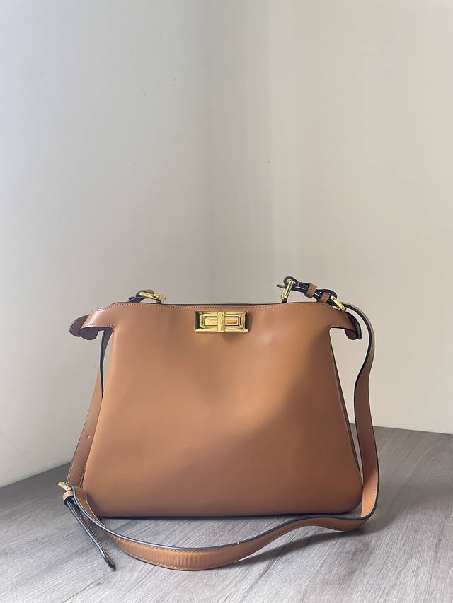 新款中号Peekaboo Soft手袋，采用头层牛皮，绒内里内衬，以硬质隔断分成两个内隔层，配有一个饰有金色Fendi标志印花的皮革内袋。铝杆以皮革包裹，减轻包