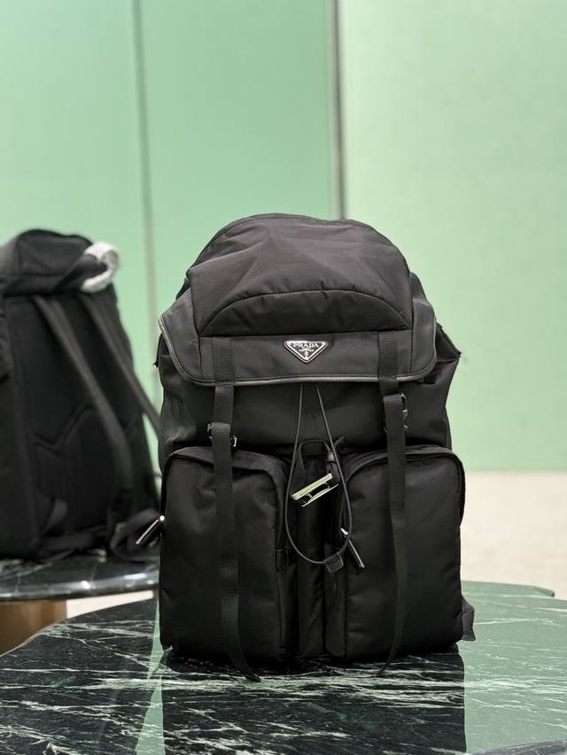 男士登山包 这款背包采用进口尼龙面料打造，颇具科技风范。背包的主隔层配翻盖和搭扣，后幅拉链式口袋，可调式编织尼龙饰带，两个外部拉链式口袋和两个束绳水壶口袋，加衬