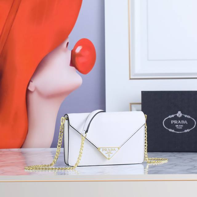 回货斜挎包1Bd669 这款翻盖式单肩包采用Saffiano皮革打造，内配小羊皮。展现匠心设计，柔美设计一览无余。翻盖开合的尖端饰以涂珐琅金属三角形徽标，配有可