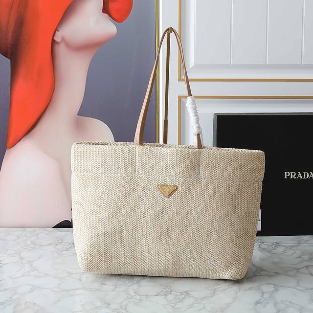新款编织托特包这款托特包采用洋溢夏日 编织托特包 这款托特包采用洋溢夏日风情的轻质天然酒椰纤维打造，柔和的解构式设计赋予包身别样的现代魅力。正面标志性的Prad