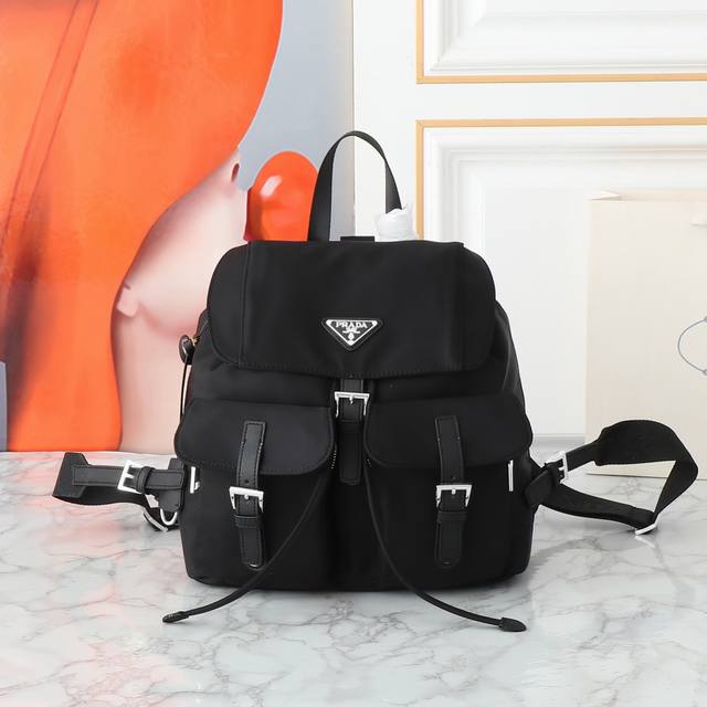 新款银扣经典背包银色五金 这款实用而创新的背包采用进口尼龙面料，可调式肩带和编织提手，可拆卸Re-Edition皮革钥匙环，正面搭扣翻盖口袋，翻盖涂珐琅三角形金