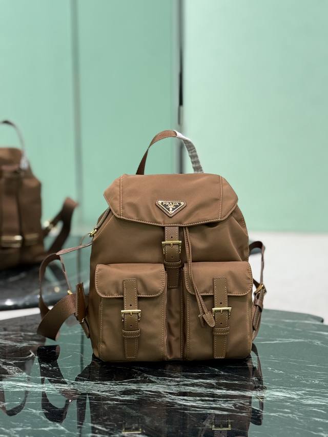 降落伞尼龙背包 P家最经典最畅销最百搭的背包，轻便防雨容量适中，出行随性搭配 进口降落伞布料-防水防晒 正面三角搪瓷徽标十字纹牛皮饰边 抽绳内袋+前面两个拉链外