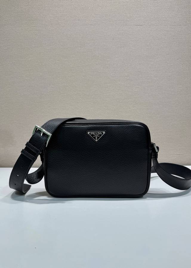 新品2Vh189 这款单肩包简约小巧，精致百搭，选用质感柔软细腻的皮革制成。装饰以标志性的三角形徽标，时尚细节点缀简约廓形。可调节肩带配金属搭扣。拉链开合 内部