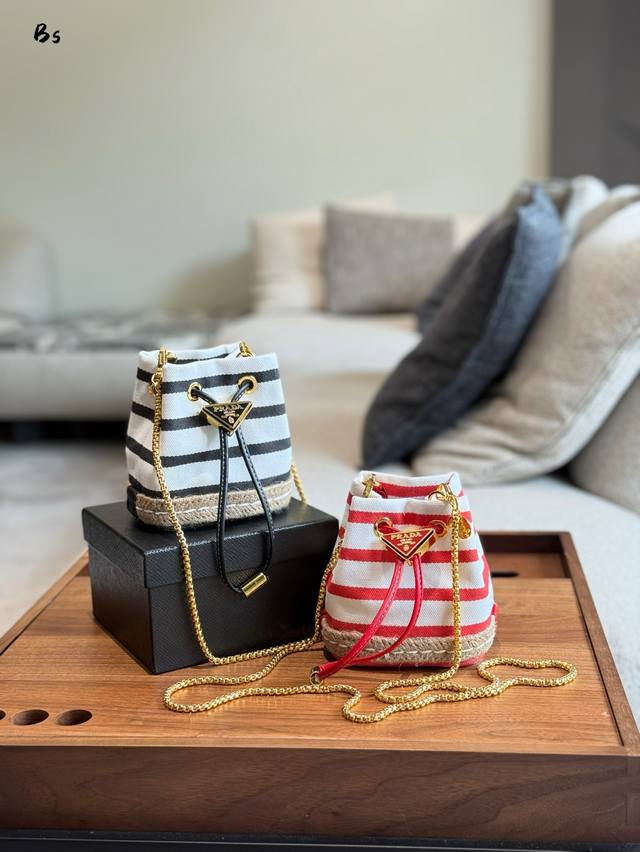 普拉达新款条纹水桶包 要迷你小水桶1Nr016条纹款逃这兴 这款迷你小包崭新诠释经典航海风元素，呈现典雅的夏日质感与精致细节。选用条纹织物打造，底部的设计灵感源