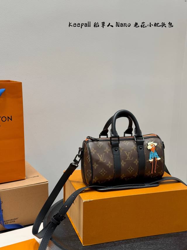 礼盒包装 Lv稻草人Keepallnano手袋为品牌于1930年推出的初始柔软旅行袋的小巧版本，将帆布与黑色哑光皮革相融合。拉链边缘旁的一抹荧光橙令此经典造型熠