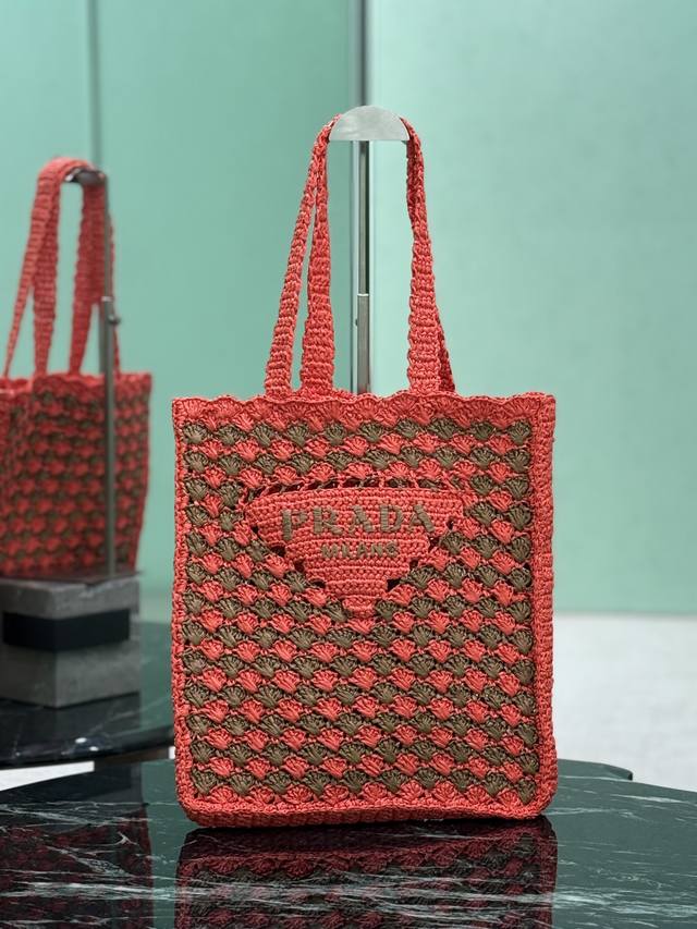 正品级 酒椰纤维托特包 这款柔和的解构式托特包以酒椰纤维材质打造，轻盈自然的材质表露夏日心绪。标志性的家三角形徽标焕新重释，装点包身正面，中心处饰以刺绣刻字徽标