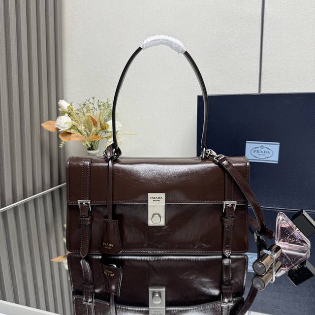 顶级原单 25Ss春夏新款咖棕 笔筒包1Bn026小号到货这款皮革手袋灵感源自挺括正式的公文包，质感细腻亮泽，以全新态度重释经典办公风格廓形。采用精致柔和细节设